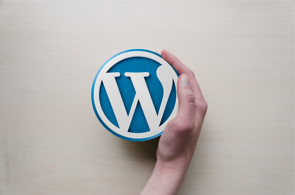 The WordPress logo with a woman's hand curled around one side of it