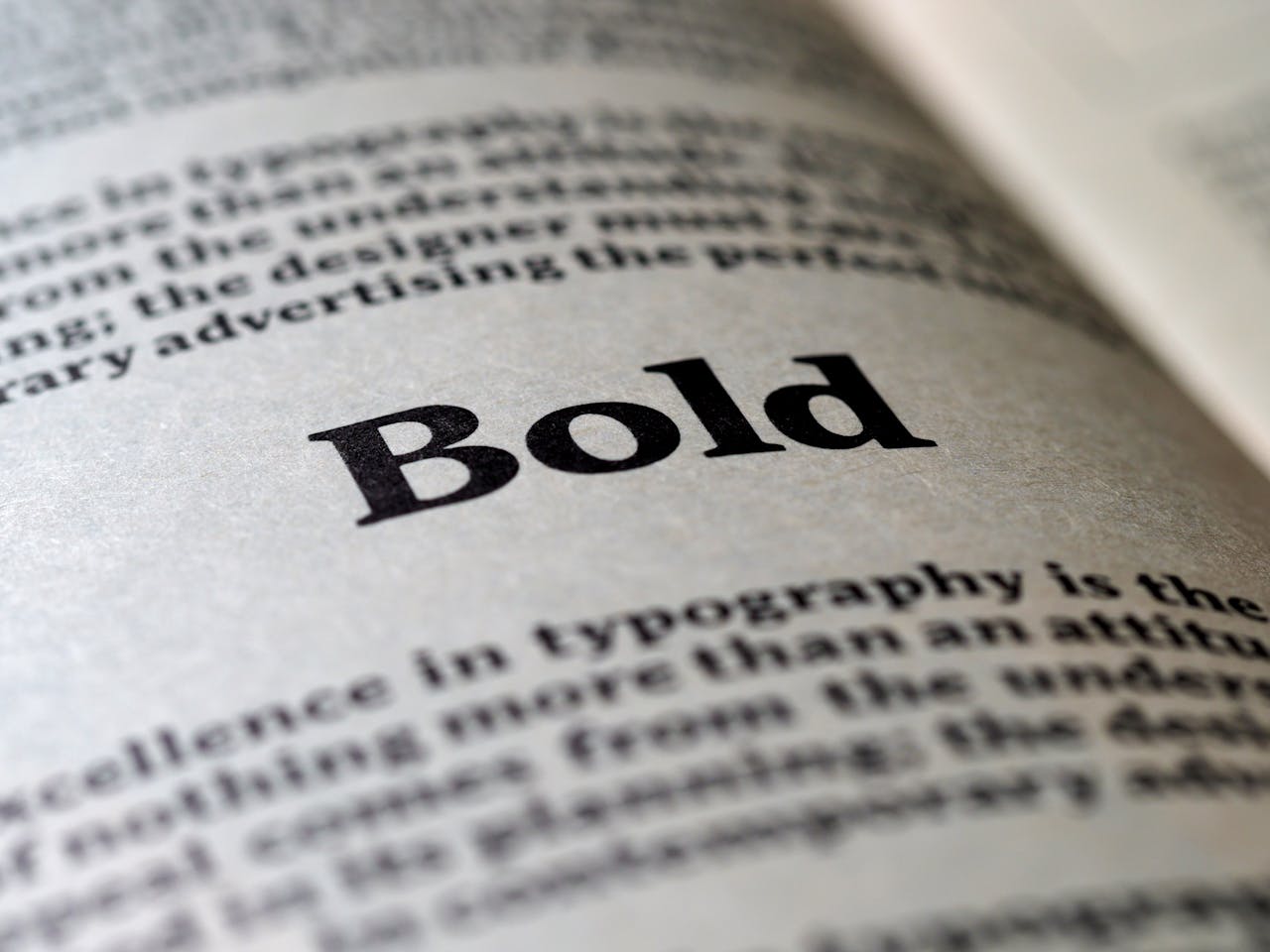 A section of an open book's page describing types of typography with the word 'Bold' written in large bold text in between two paragraphs.